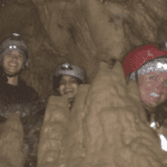 3 cavers smiling after a difficult climb