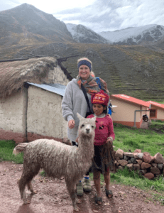 Hostel Mom in Peru with a local child and an alpaca