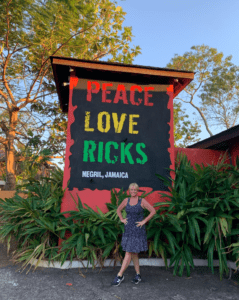 The Hostel Mom standing in front of a Rick's cafe sign